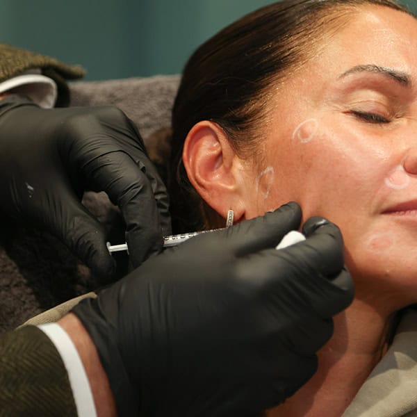 Woman receiving facial injection treatment at Cannelle Skin Clinic, skincare specialist performing c.