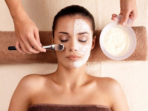 Woman receiving a facial treatment with cream application at Cannelle Skin Clinic.