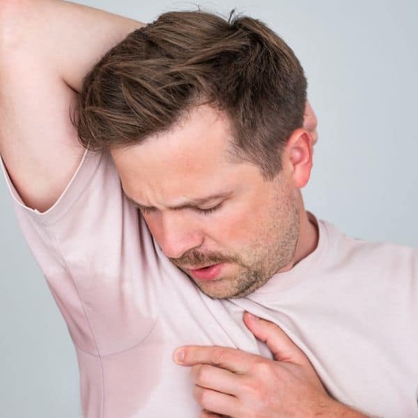 Man examining underarm skin, seeking skin care treatment or advice.