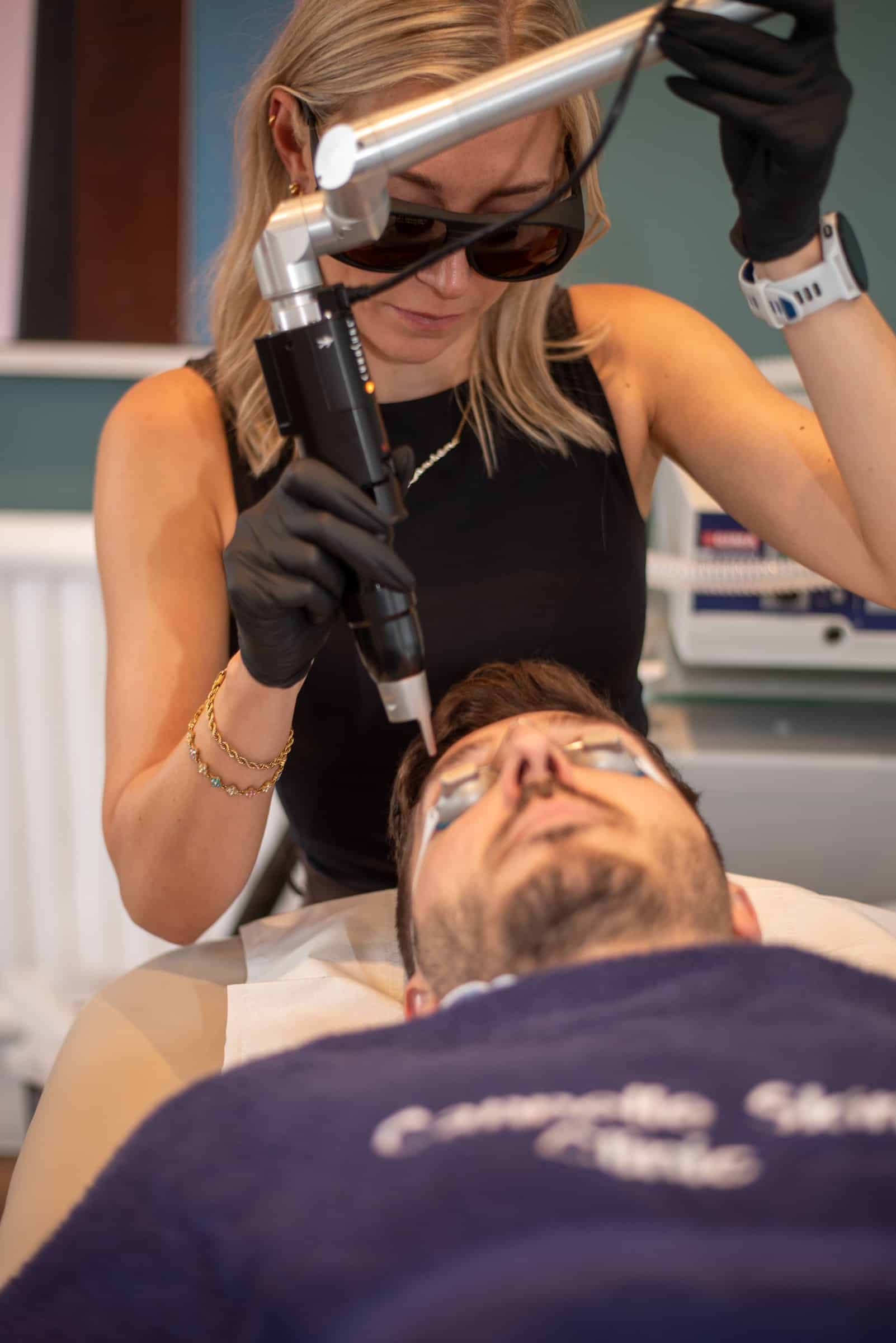 A Cannelle therapist in protective eyewear guides the PicoSure handpiece over a patient's face