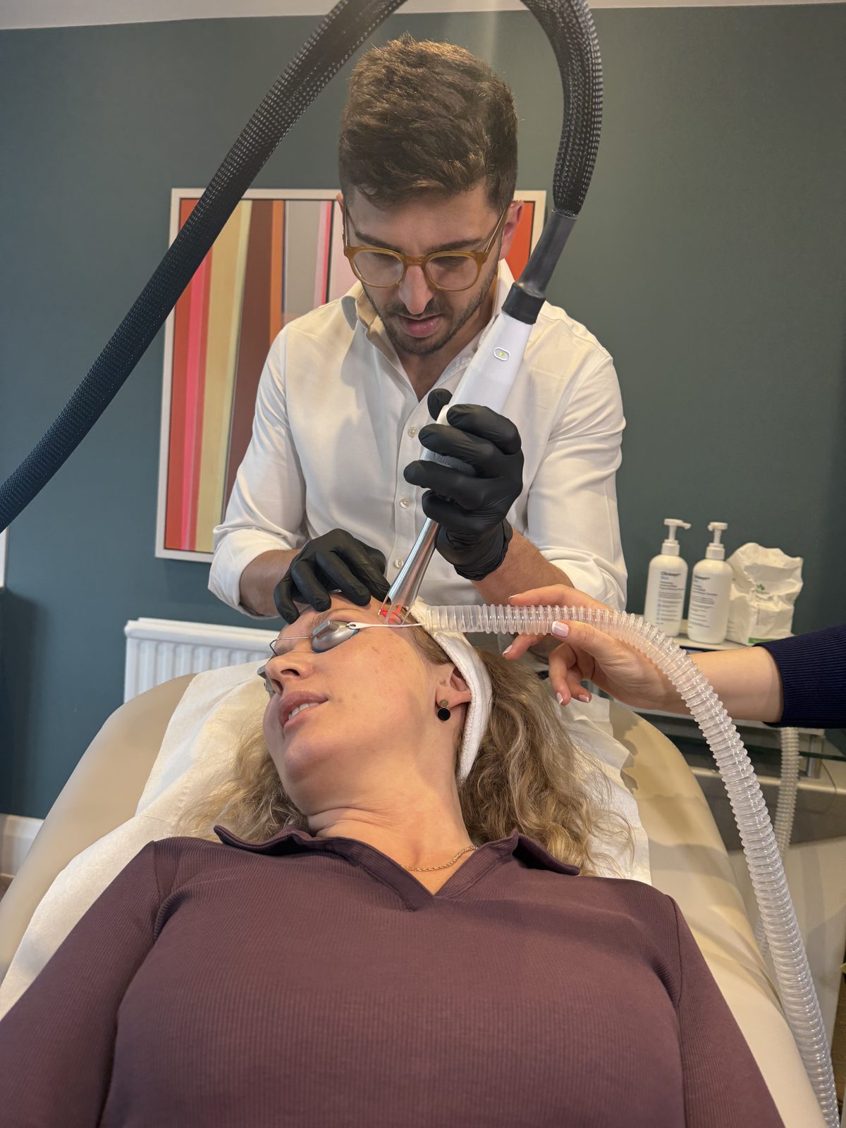 The UltraClear handpiece moving across the cheek during a live treatment